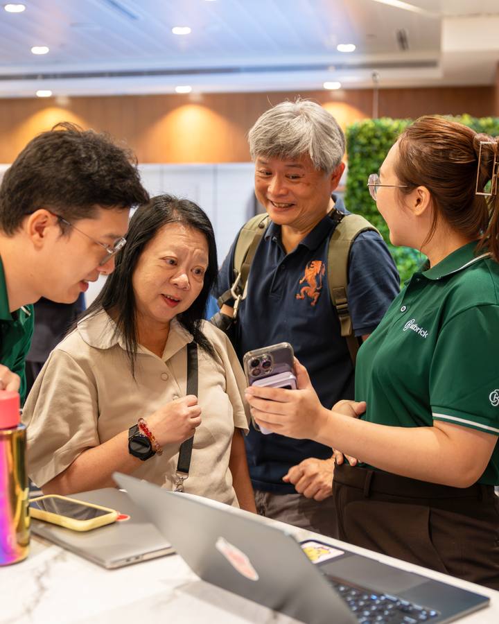A Crestbrick associate briefing clients over a laptop on the Kuala Lumpur trip