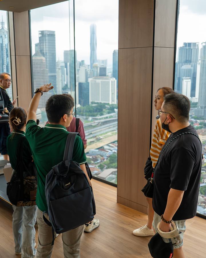 Clients taking in the Kuala Lumpur skyline from a high-floor unit
